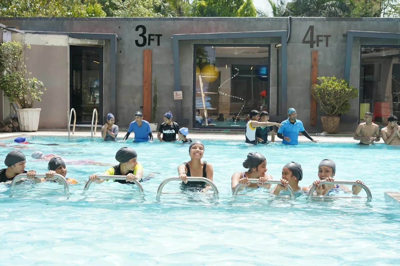 Children in a swimming class with their instructors