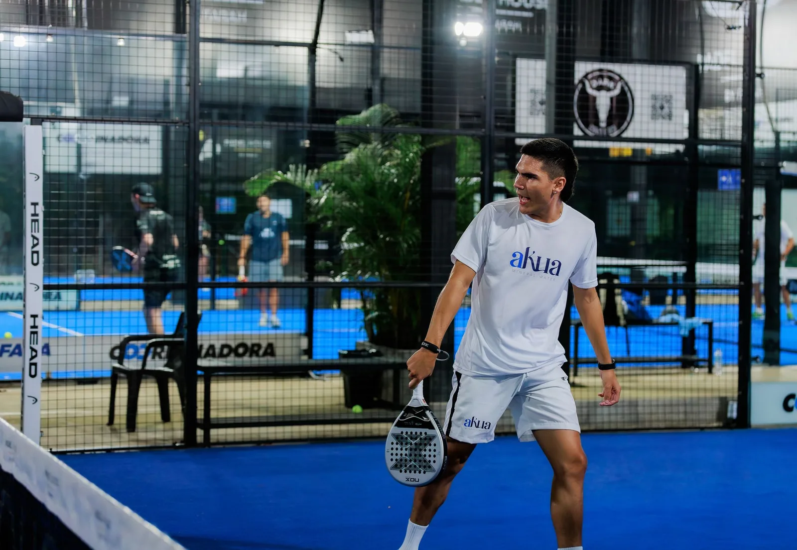 A padel player mid-rally